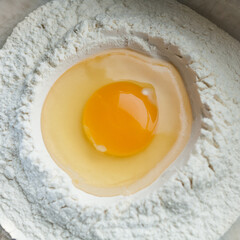 Broken egg on wheat flour. To make homemade pasta, bread, pastries. Top view.
