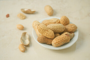 peanuts in a white plate on a kitchen top 