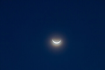 Naklejka na ściany i meble Crescent moon on blue sky. Look like a smile on a good day.