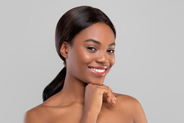 Portrait of smiling pretty millennial african american woman with shining hair and perfect skin...