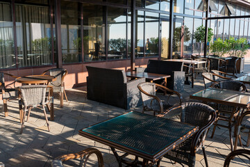 Summer cafe with wooden tables and wicker chairs.