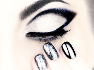 Beautiful female black and silver makeup and manicure. Female eye with black arrow.