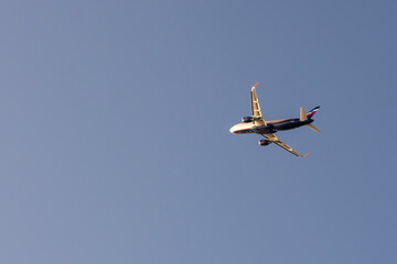 Blue passenger plane against the background of the evening sky.