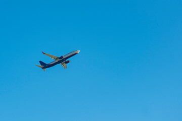 Fototapeta na wymiar Blue passenger plane against the blue sky.