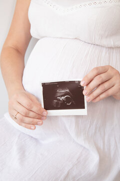 pregnant woman with a photo of ultrasound of pregnancy. enjoying pregnancy happy time. mother to be with cute big tummy