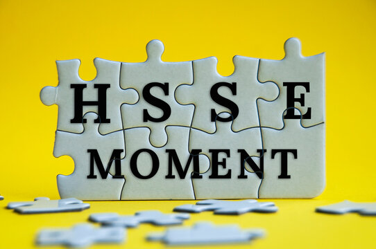 HSSE moment text on jigsaw puzzle with yellow background - Health, Safety, Security and Environment.
