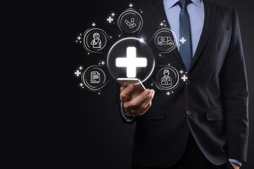 Businessman hold virtual plus medical network connection icons. Covid-19 pandemic develop people awareness and spread attention on their healthcare.Doctor,document,medicine,ambulance,patient icon.