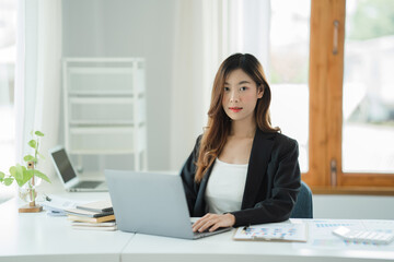 Asian woman working in the office using a laptop.