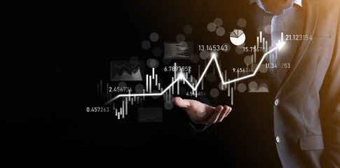 Fototapeta premium Businessman in hand hold banking business finance graph and invest in stock market investment point,economic growth and investor concept.analysis virtual stock market chart,analyze by use technology