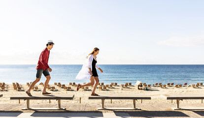 Happy young couple having fun together while enjoying summer vacations at the beach in Barcelona. Travel and relationship concept. Copy space for text