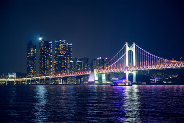 Fototapeta na wymiar Gwangan Bridge and skyscrapers illuminated in the night. Busan, South Korea