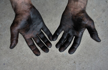 male worker hands in black oil on a gray background