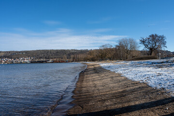 Naklejka premium A winter beach covered with snow and a blue sky in the background