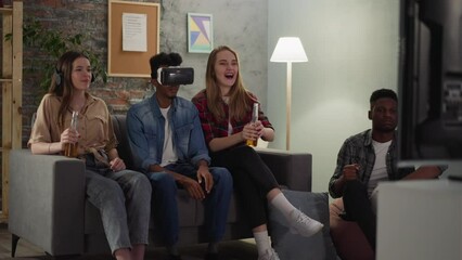 Black man with VR headset and positive friends watch basketball game in apartment slow motion. Digital technology of augmented reality for sports fans - Powered by Adobe