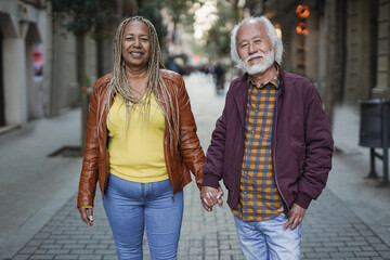 Happy multiracial senior couple holding hands in the city - Love conept - Powered by Adobe