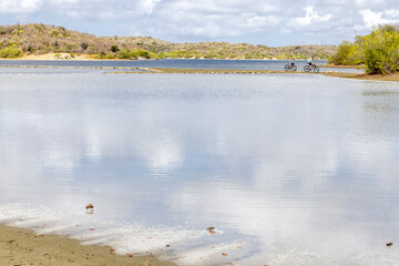 Two people cycling across the Jan Thiel Salt Flats on the Caribbean island Curacao