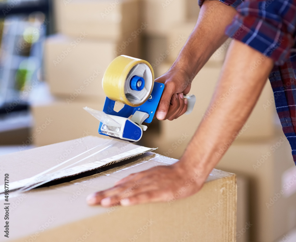 Poster this seals the deal. shot of an unidentifiable man using a tape dispenser to close a box while movin