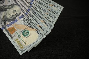 one hundred dollars close up on black background