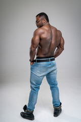 Fototapeta premium Young bodybuilder with athletic torso. Muscular strong man posing in studio.