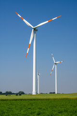 Modern wind turbines on a sunny day seen in Germany - 498772911
