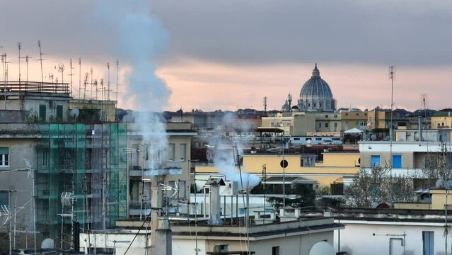 I tetti di Roma, i comignoli che fumano sullo sfondo la cupola di San Pietro
Riscaldamento, consumo del gas e inquinamento in citt&agrave;.
