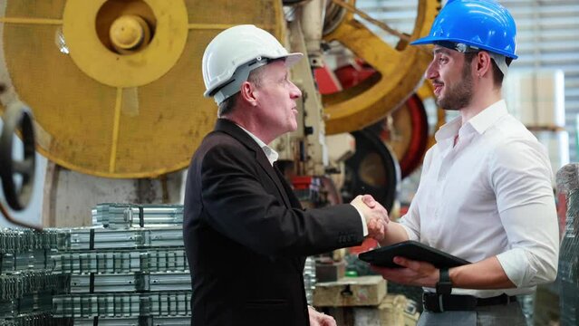 Caucasian business man and Factory engineer talking and  shaking hands on business cooperation agreement. Successful hand shaking after good deal