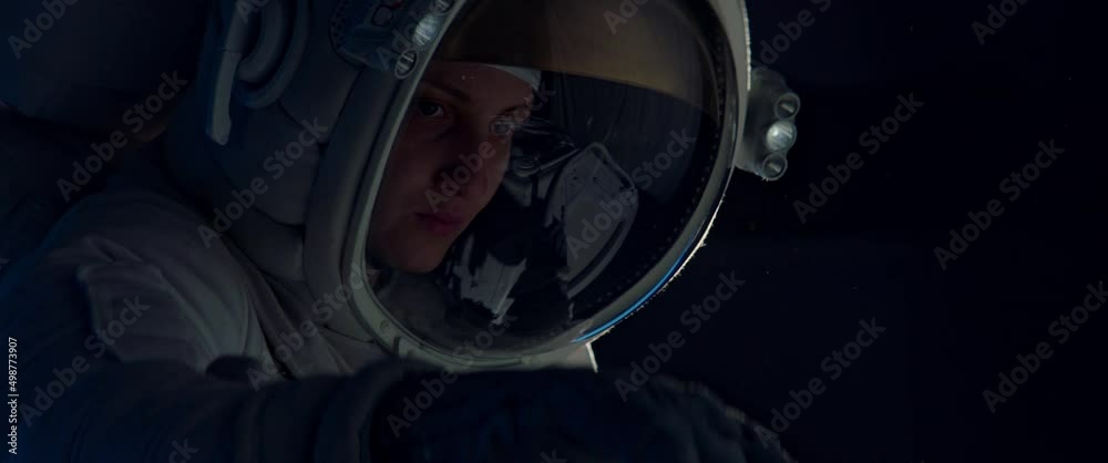 Wall mural female astronaut performing spacewalk, working on a outer part of a space craft. shot with 2x anamor