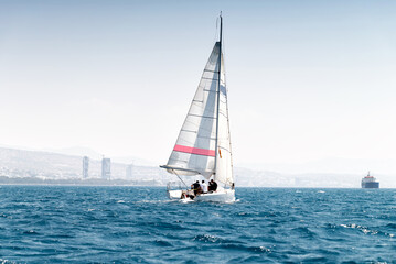 Sport sailboat in calm sea, Limassol in the background