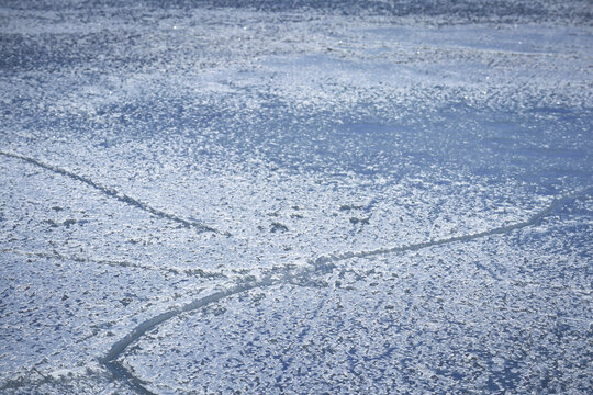 Snowy Ice Surface With Cracks In Blue Shades And Vignette