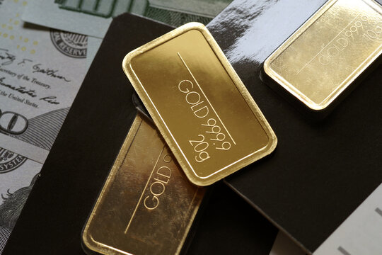 Gold bars on the background of dollar bills. Selective focus.