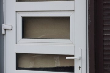 white metal door handle on gray plastic and glass door in the street