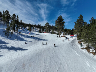 People skiing and snowboarding in mountain ski resort during winter season
