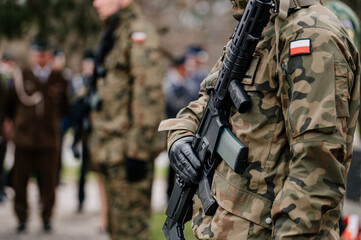 Polski żołnierz trzymający broń - obrazy, fototapety, plakaty
