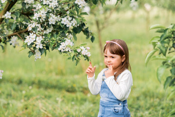 Portrait of a girl in a spring garden near blooming apple trees