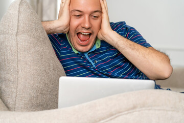 Excited guy feel euphoric receiving pleasant email message on laptop. Emotional man celebrating...