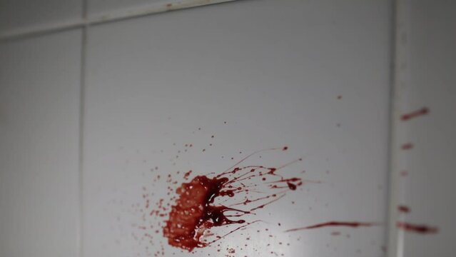 Blood Splats onto white tiled wall