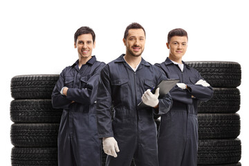 Mechanics standing with piles of tires