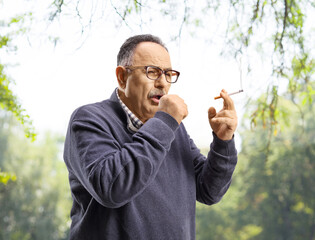 Mature man smoking and coughing outdoors © Ljupco Smokovski