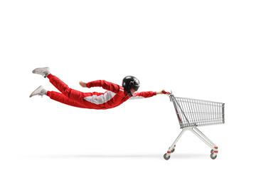 Car racer in a red suit and black helmet flying with an empty shopping cart
