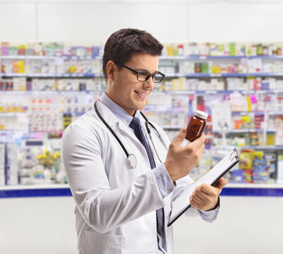 Pharmacist Looking At A Bottle Of Pills In A Pharmacy