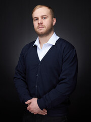 vertical portrait  blond man on a dark background, in a jacket