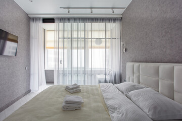 Master bedroom with sliding wardrobe and balcony door. Elegant and comfortable hotel bedroom interior