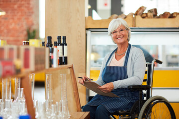 I stay on top of my stock. Portrait of a senior woman in a wheelchair doing stock take in her coffee shop.