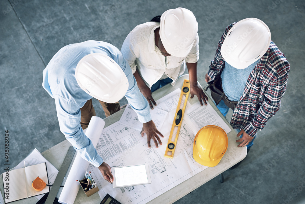Poster Taking clients designs to the next level. Shot of a group of builders having a meeting at a construction site.