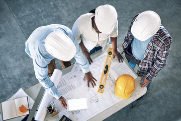 Taking clients designs to the next level. Shot of a group of builders having a meeting at a...