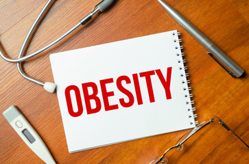 OBESITY text on white paper on the white background. stethoscope