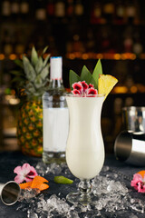 Pina Colada cocktail, against the background of bottles, on the bar, with bar attributes