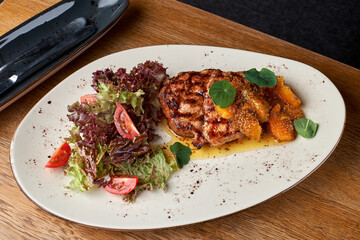 Pork neck with orange mustard and fennel. Pork Neck steak of grilled Pork shop steak in white plate.