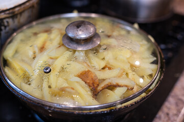 Fried potatoes on the iron frying pan close-up on the table