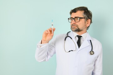 male doctor holding syringe, isolated blue background.